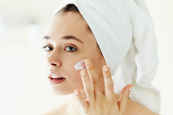 image of a woman using the lotion to improve acne damaged skin