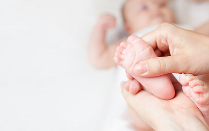 Image of Person applying Baby Massage Oil on her Baby's Feet