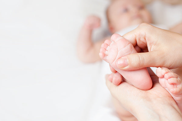 Image of Person applying Baby Massage Oil on her Baby's Feet