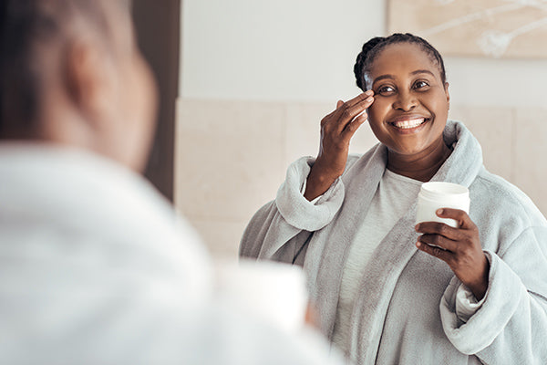 Image of Woman Using Exfoliating Cleanser in her Bathroom