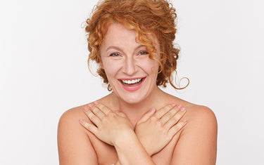 Image of a happy mature woman having applied hydrating body lotion