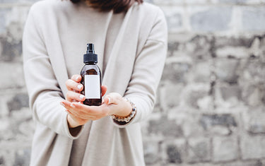 Image of Woman Holding a bottle of Invigorating Toner