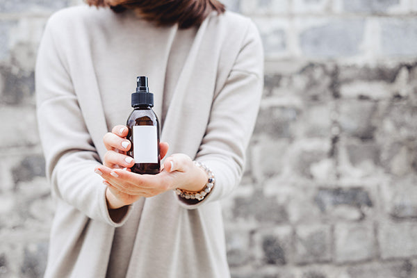 Image of Woman Holding a bottle of Invigorating Toner