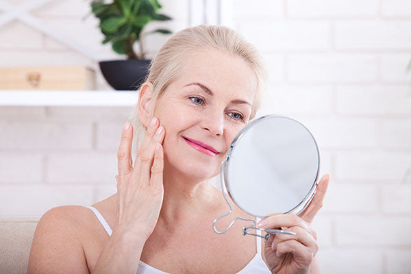 image of a woman using age defying oil serum