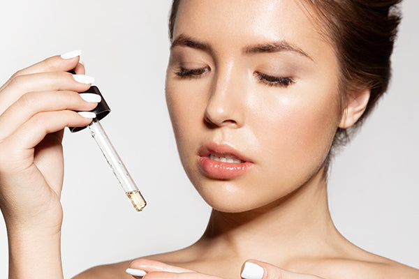 image of a woman using the facial serum with argan oil