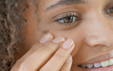 image of a woman applying rich eye cream