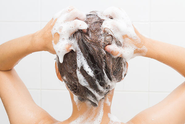 Image of woman using gentle shampoo in the shower