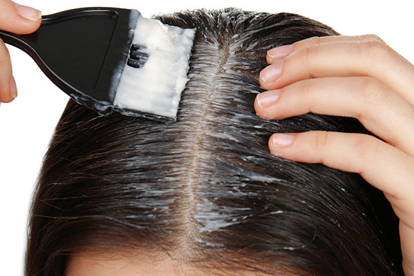 image of woman applying watermelon and mango hair conditioner on her roots