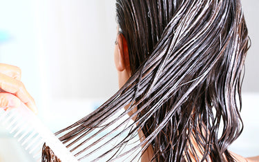 image of woman applying conditioning hair butter