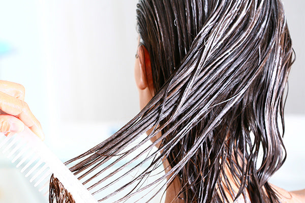 image of woman applying conditioning hair butter