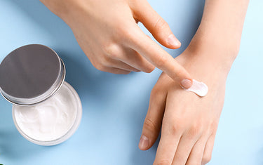 image of someone applying cream to lighten age spots and stained fingers on hands