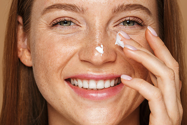 image of woman using lotion for oily skin