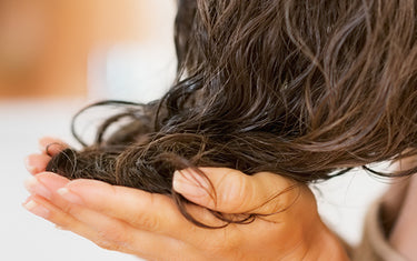 image of someone applying moringa shiny hair oil