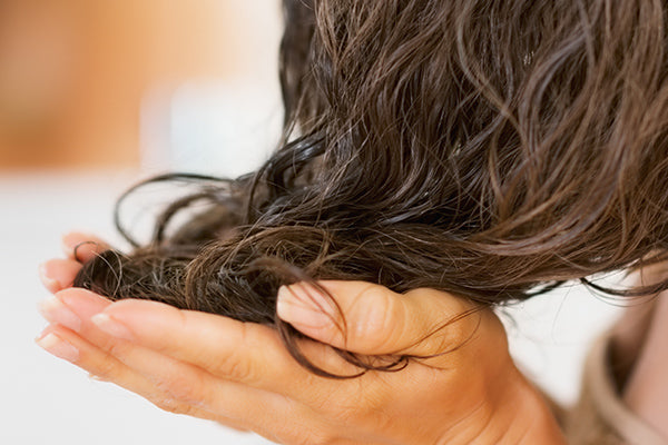 image of someone applying moringa shiny hair oil