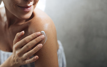 Image of a woman using the spray body lotion on her body