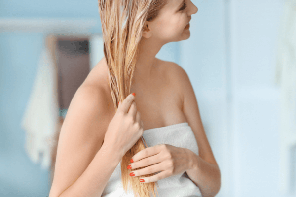 image of a woman using spray on hair conditioner