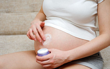 image of a pregnant woman using stretch mark and scar tissue balm