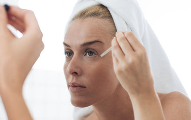 image of mature woman using facial oil suitable for skin prone to spider veins